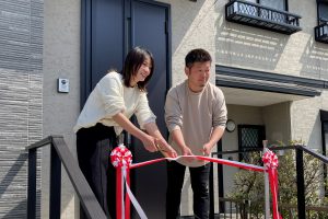 引き渡し式でリボンを切るオーナー様